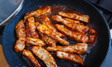 Akşam yemeği için sıcak tavada pişen domuz eti şeritleri. Karamel soslu ve karabiberli biftek. Egzotik tarifle hazırlanmış baharatlı bbq yemeğinin tadını çıkarın.