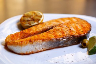 Akşam yemeği için deniz ürünleri restoranında ızgarada pişirilmiş lezzetli somon balığı bifteği. Sağlıklı yemek için doğal malzemelerle hazırlanmış gurme yemeği. Öğle yemeği için ızgara kırmızı balık filetosu.