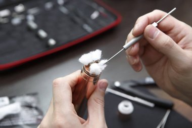 Dövmeci el fırçayla sigara tutuyor.