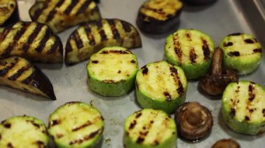 Mutfaktaki metal tepside ızgara sebzeler yakından çekiliyor. 