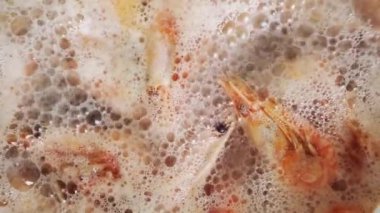 Mutfakta sıcak suda karidesler kaynıyor. Şef paella için karides pişiriyor. Restoranda egzotik Akdeniz yemekleri için deniz ürünleri pişiriliyor.