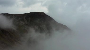 Karpatlar 'daki yoğun sis ve dramatik bulutların güzel görüntüleri. Avrupa 'da dağın zirvesinde soğuk bir sonbahar günü. Batı Ukrayna 'da doğanın güzelliği. Yürüyüş için kötü bir hava.