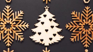 Ev dekorasyonu için kullanılan ahşap kar tanelerinin video klibi 4K ultra HD ile doğrudan yukarıdan çekildi. El yapımı kar tanecikleri ve Noel oyuncakları siyah arkaplandaki görüntüler büyütme etkisi yaratıyor 