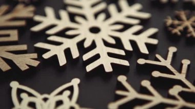 Ev dekorasyonu için kullanılan ahşap kar tanelerinin video klibi 4K ultra HD ile doğrudan yukarıdan çekildi. El yapımı kar tanecikleri ve Noel oyuncakları siyah arkaplandaki görüntüler büyütme etkisi yaratıyor 