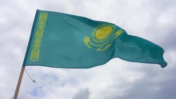 カザフスタン共和国国旗空の青の背景に金色の飛脚鷲の上に32本の光線と国の装飾パターン Koshkar Muiz ラムの角 と呼ばれる金の太陽 — ストック動画