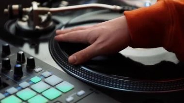 Yakın çekimde Hip Hop DJ analog turntable ve ses karıştırıcı ile vinil plakları kaşıyor.
