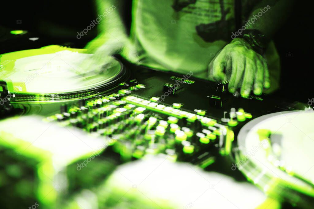Party dj scratches vinyl records with hip hop music on vintage turn table player.Illustration edited with neon green effect.Hands of concert disc jockey scratching record on retro turntables 