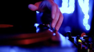Gece kulübünde konser sahnesinde analog dj turntable. Profesyonel disk jokeyi masa başı oyuncusu, gece kulübünde çılgın bir partide müzik eşliğinde vinil plak çalıyor.