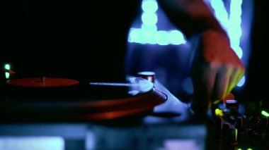 Konser DJ 'i turntable ve vinil plaklarla müzik çalıyor. Profesyonel kulüp jokeyi neon ışıklarıyla sahnede müzik parçaları çalıyor. DJ gece kulübünde parti ayarlıyor ve video klipte çekiliyor.