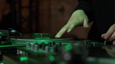 Hip hop DJ 'i partide müzik çalıyor. Profesyonel disk jokeyinin video klibi gece kulübünde. Profesyonel DJ retro ses ekipmanı yavaş çekim çekimlerinde çekildi.