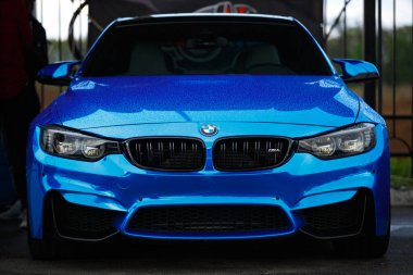 KYIV-15 Mayıs 2021: Mavi BMW M4 F83, Drift And Car Show 'da mavi krom ambalaja sarılı. Kurşun farları ve geniş gövdesi olan lüks bir Alman aracı.