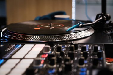Profesyonel DJ tuzağı. Vinil plaklı analog turntable ve ses karıştırıcı ve itme pedleri. Gece kulübünde konser sahnesinde yüksek kaliteli disk jokey ses ekipmanı. 