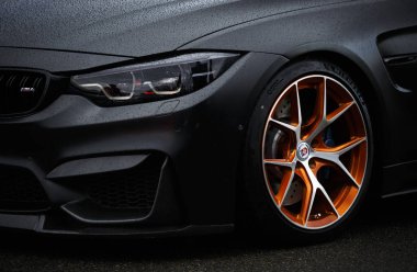 KYIV-15 MAY,2021: BMW M4 F83 wrapped in matte black vinyl wrap and equipped with custom wide body kit and forged wheels with low profile tires. Beautiful modern German vehicle on Drift And Car Show clipart