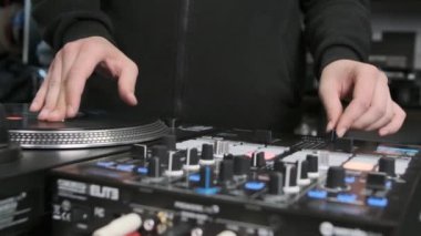 Hip hop dj scratches vinyl records in slow motion video clip. Professional disc jockey mixing tracks on party with retro turntables and sound mixer  