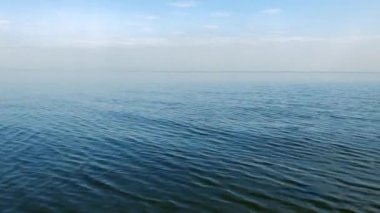 Yazın gün batımında deniz suyunda dalgalanma. Tatil köyünde çekilen güzel bir manzara videosu.