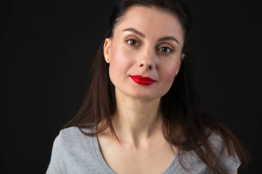 Profesyonel makyajlı ve kameraya kırmızı ruj süren güzel esmer kadının stüdyo fotoğrafı.