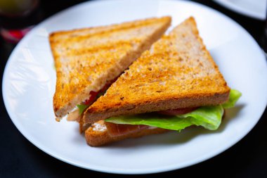 Amerikan lokantasında kahvaltıda servis edilen kulüp sandviçi. Öğle yemeğinde geleneksel fast food yemeği.