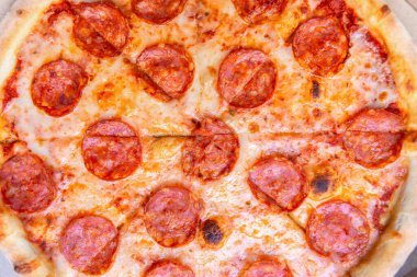 Pepperonili pizza manzaralı. Fırında pişmiş lezzetli pizza tabağı. Hamurda pişmiş sosis, mozarella peyniri ve domates sosu. İtalyan restoranında pişirilen fast food 'u götür.