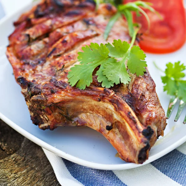 Carne di maiale alla griglia sul piatto con insalata verde — Foto Stock