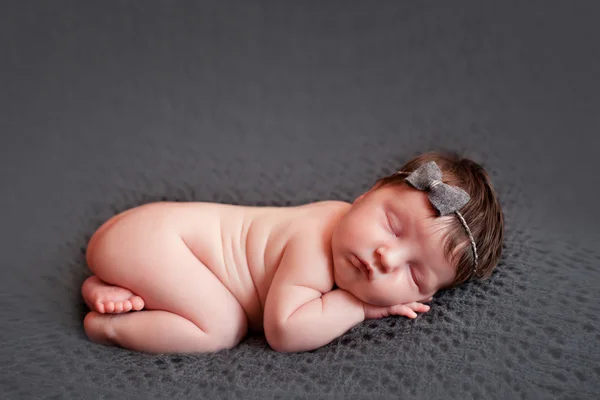 Pasgeboren babymeisje op grijze achtergrond — Stockfoto