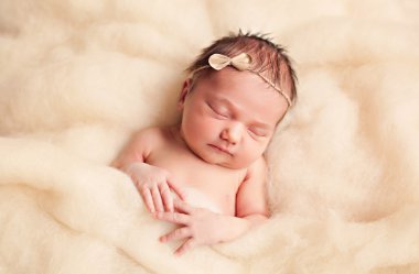 Newborn baby girl in wool fluffy clouds clipart