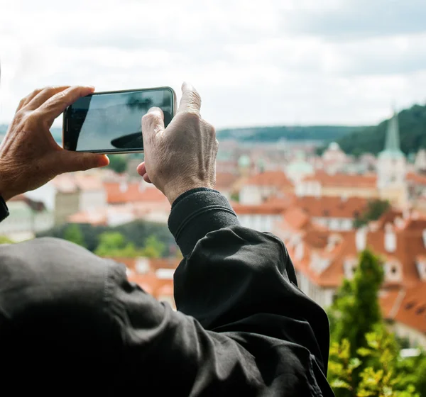 Oudere man is het maken van foto's van uitzicht op de stad met een mobiele telefoon — Stockfoto
