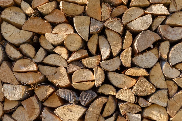 Im Winter geerntetes Brennholz zum Heizen. Ein Haufen Brennholz im Hof des Hauses auf dem grünen Gras — Stockfoto
