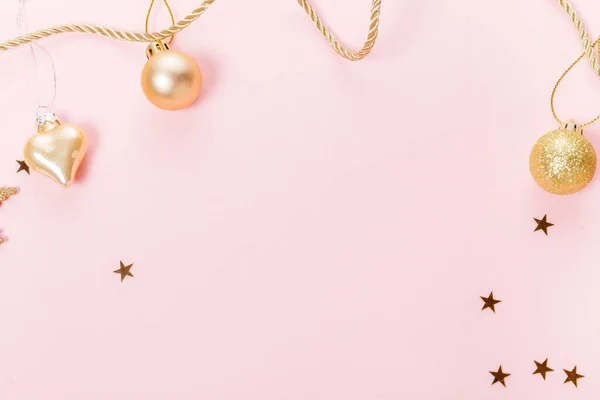 Weihnachtskomposition. Festliche kreative Goldmuster, Weihnachten goldenen Dekor Weihnachtskugel mit Schleife, Schneeflocken auf rosa Hintergrund. — Stockfoto