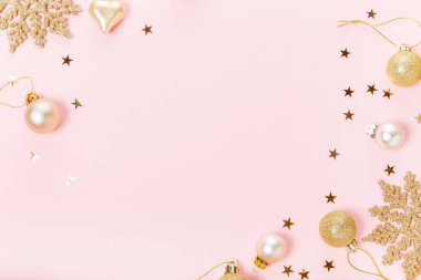 Noel kompozisyonu. Şenlikli yaratıcı altın desenli kostüm, kurdeleli altın desenli tatil balosu, pembe arka planda kar taneleri..