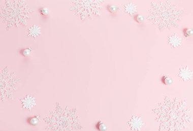 Beyaz Noel bayramı kompozisyonu. Şenlikli yaratıcı beyaz desen, Pembe arka planda kar taneleri olan xmas dekor tatil balosu.