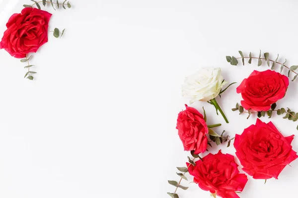 Composición de flores. Marco hecho de flores de rosa roja sobre fondo blanco. Plano, vista superior, espacio para copiar —  Fotos de Stock
