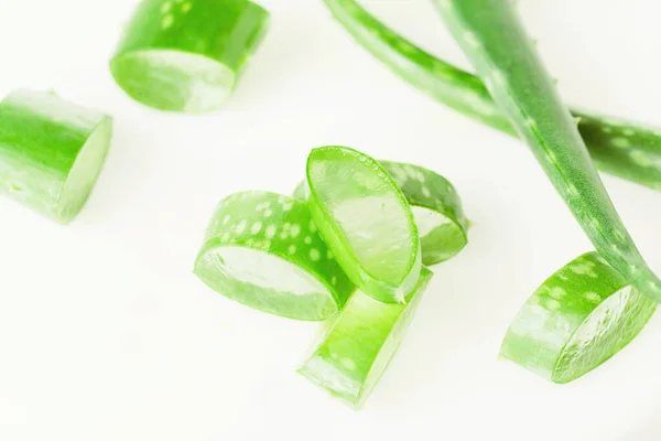 Green fresh aloe vera leaves and slices on white background. Top view. Flat lay. — Stock Photo, Image