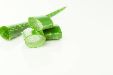 Yeşil taze aloe vera yaprakları ve beyaz arka planda dilimler. Üst Manzara. Düz yatıyordu.