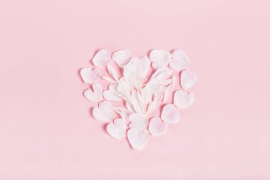 Pembe arka planda kalp şeklinde pembe gül yaprakları. Düz yatış, üst görünüm