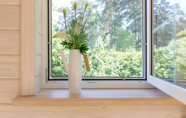 Ventana blanca con mosquitero en una casa de madera rústica con vistas al jardín. Ramo de iris blancos y altramuces en regadera en el alféizar de la ventana — Foto de Stock