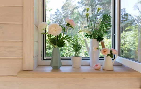 Janela branca com mosquiteiro em uma casa de madeira rústica com vista para o jardim. Buquê de íris brancas e tremoços na lata de rega no peitoril da janela — Fotografia de Stock