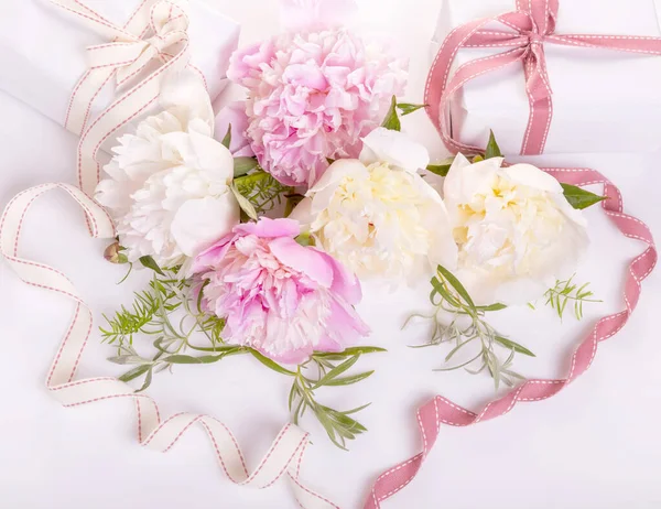 Tarjeta romántica, delicadas peonías blancas flores y regalos, cintas en forma de corazón. —  Fotos de Stock