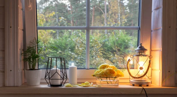 Yellow roses on windowsill, candles, autumn leaves, lantern. — Stock Photo, Image