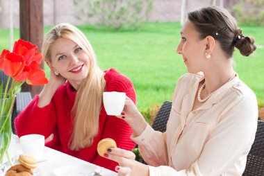 İki güzel kadın kahve bir fincan gülümseyen