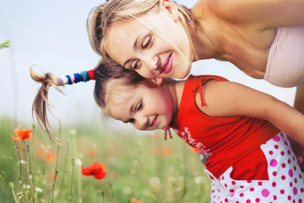 Mutlu aile yaz aylarında çiçek çayır üzerinde eğlenceli almak — Stok fotoğraf