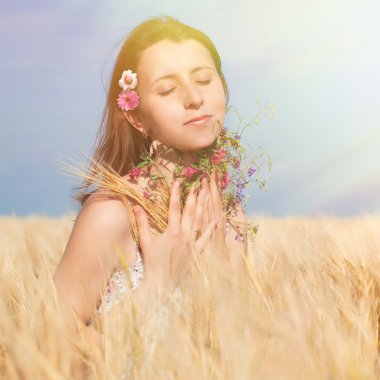 Kır çiçekleri yaz buğday alanında kadınla.