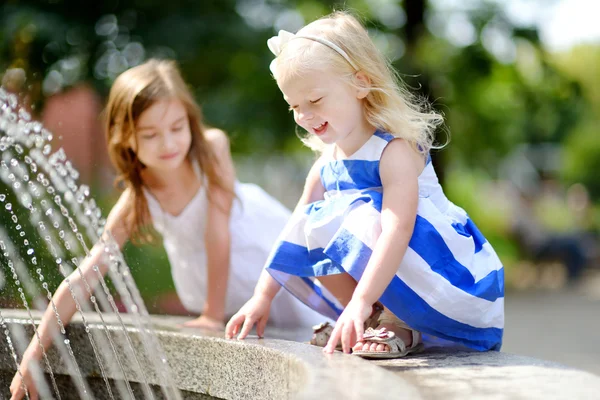 Girls playing with a city fountain — Stock Photo, Image