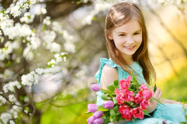 Weinig meisje bedrijf tulpen — Stockfoto
