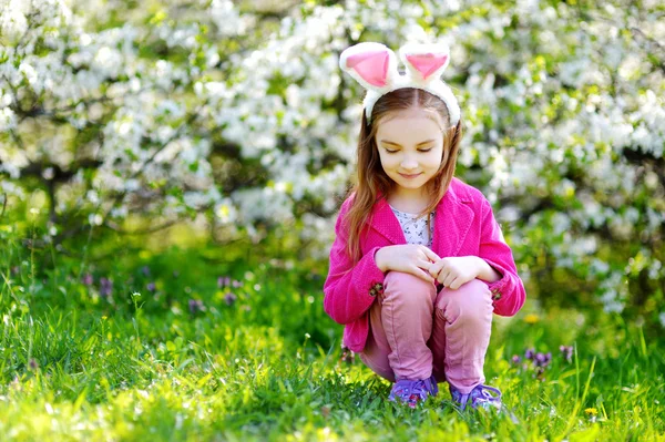 Schattig klein meisje in bloeiende kers tuin — Stockfoto