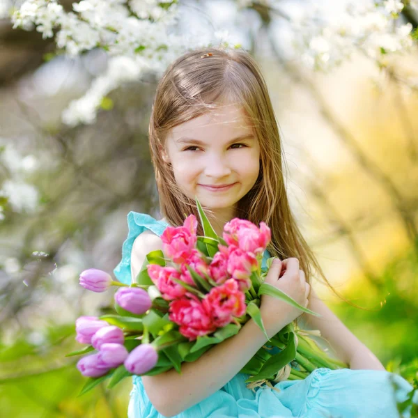 Malá dívka hospodářství tulipány — Stock fotografie