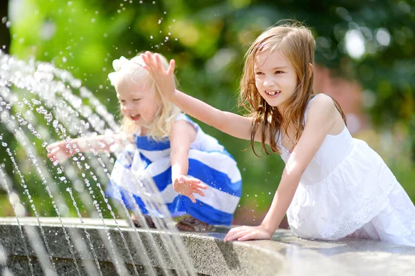 Meninas brincando com uma fonte da cidade — Fotografia de Stock