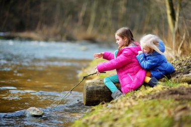 bir nehir tarafından sopayla oynayan kız