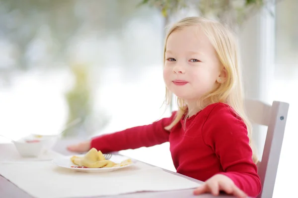 Menina bonito ter crepes para o café da manhã — Fotografia de Stock