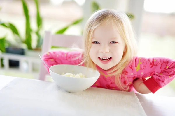 Tjej som har havregrynsgröt till frukost — Stockfoto