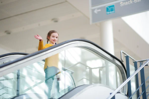 Child standing on moving staircase — Stock Photo, Image